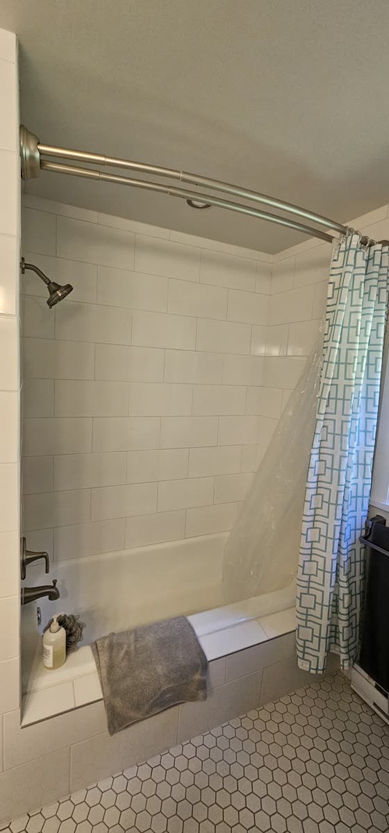 Tub and shower renovation — subway tile surround close-up, chrome fixtures
