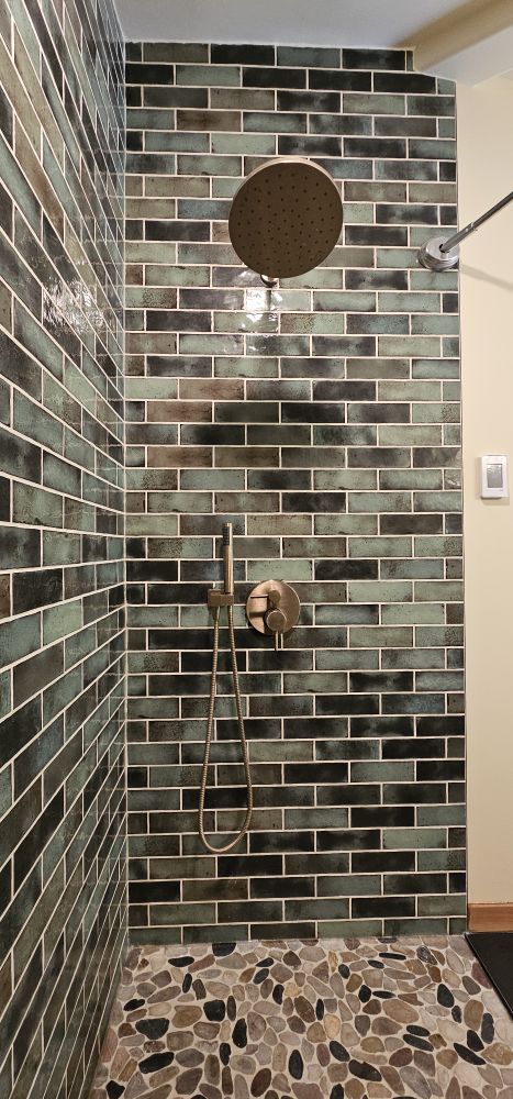 Sky & Tasha bathroom renovation — custom handmade tile walk-in shower, rain head, pebble floor