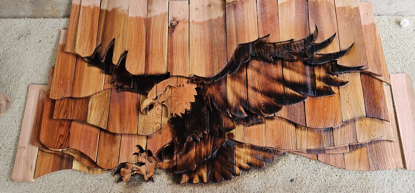Terri Wylie project — custom eagle motif flat panel installed on cedar shake siding exterior
