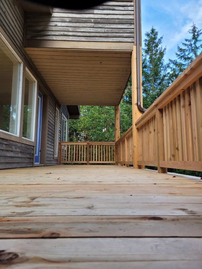 New cedar deck — covered soffit, cedar railings, low-angle view · SSI
