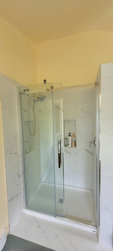 Bathroom renovation — marble tile shower enclosure, frameless glass door · Salt Spring Island